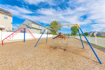 Small community playground near the fenced residential houses at Utah Valley