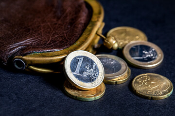Old wallet and Euro coins on a dark background