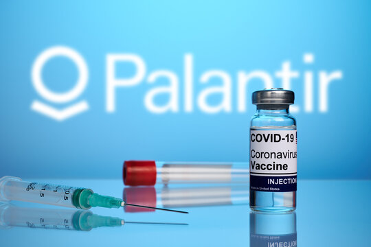 Krasnoyarsk, Russia - April 29, 2021: Palantir Covid vaccine and syringe - photo on a blue gradient background. Antiviral vaccine against coronavirus. Blurred Palantir logo for antivirus service.