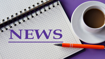 NEWS - word in a white notebook on a purple background with a cup of coffee
