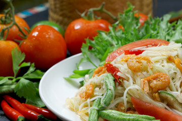 Thai papaya salad, Thai traditional Thai papaya salad Cooked with papaya, tomatoes, green beans and peanuts. Spicy Thai food concept.