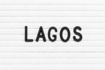 Black color letter in word lagos on white felt board background