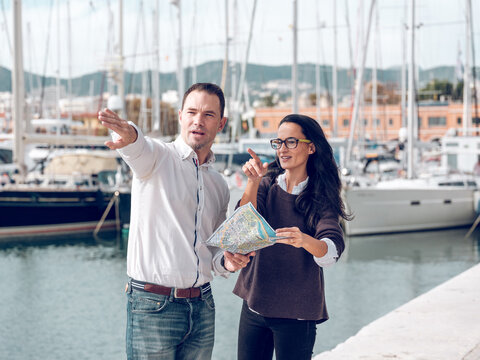 Man Pointing Away While Explaining Route To Ethnic Woman