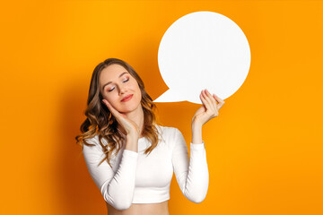 Student girl dreams and holding round blank speech bubble isolated on an orange background. Copy space