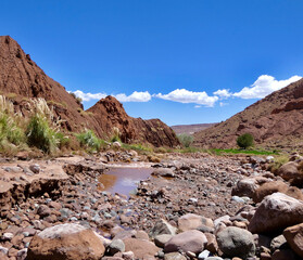 Desert stone landscape in brown water  river in Atacama desert landscape, with blue sky