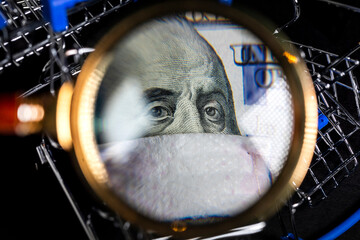 Portrait of Ben Franklin wearing medical mask on one hundred dollar bill on background of shopping carts