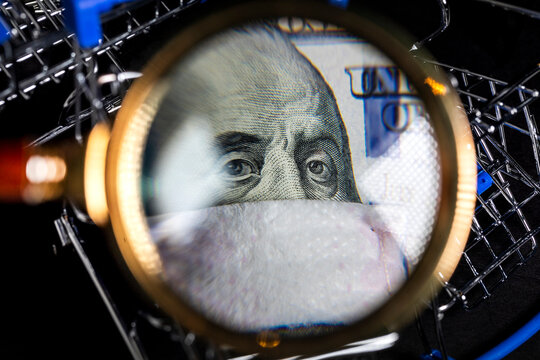 Portrait Of Ben Franklin Wearing Medical Mask On One Hundred Dollar Bill On Background Of Shopping Carts