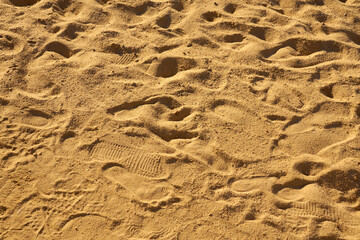 Footprints in the sand in the sun as a backdrop.
