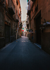 Narrow dark alleyway with Italian flag in the old town of Taranto
