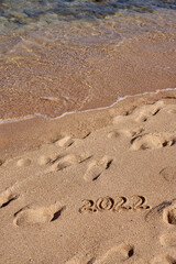 Inscription 2022 on the sand on the shores of the Red Sea.