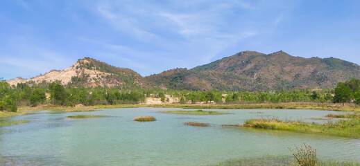 Natural scene including trees, lakes and sand and rocks with many colors