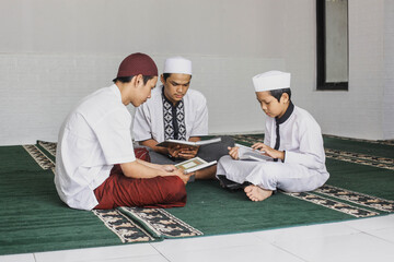 Group of male Muslim teenagers who fill their spare time by taking turns reading the Koran in the...