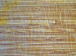 Close up detail on cutting board with knife cut marks. Textured background.