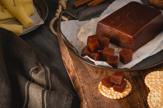 Quince cheese or marmelada is a sweet, thick jelly made of the pulp of the quince fruit. Marmalade in crackers on a kitchen counter. Dulce de membrillo in Spain