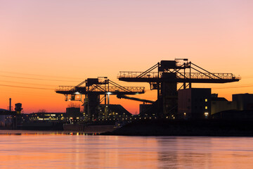 Fototapeta na wymiar Cranes in a harbour at sunrise