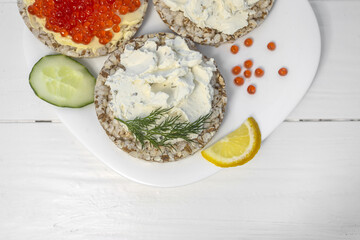 Crispy wheat crackers with red caviar, spread, dill and lemon. Natural Diet Bread