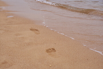Footprints of a man on the sand on the beach.