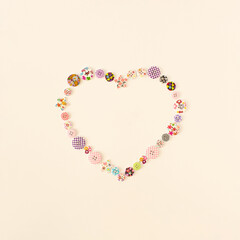 Obraz premium Heart shaped made of colorful buttons on white bright background. Valentine's day or Mothers' day concept.