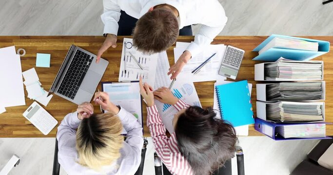 Business people upset with financial report at workplace top view