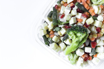 Frozen vegetables in transparent dishes on a light background. The concept of using quick-frozen products