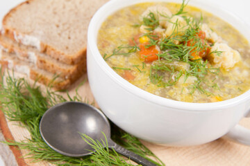 Vegetable and chicken soup with decorated with dill, served with fresh bread