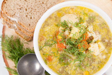 Vegetable and chicken soup with decorated with dill, served with fresh bread