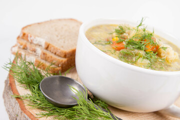 Vegetable and chicken soup with decorated with dill, served with fresh bread