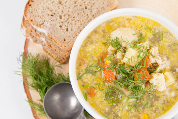Vegetable and chicken soup with decorated with dill, served with fresh bread