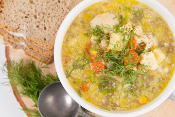 Vegetable and chicken soup with decorated with dill, served with fresh bread