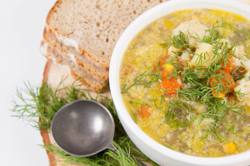 Vegetable and chicken soup with decorated with dill, served with fresh bread