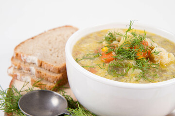 Vegetable and chicken soup with decorated with dill, served with fresh bread