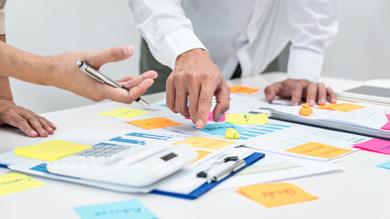 Two business people pointing keyword in post it notes on the table during brainstorming about new...