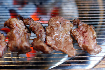 Meat is being grilled on charcoal.