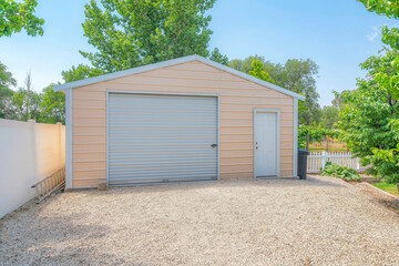 Detached gable garage exterior with steel walls and roll-up door with door latch lock - obrazy, fototapety, plakaty