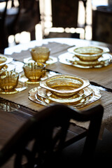 table setting with an antique glass service with a filigree pattern. yellow glass service in a renaissance style interior. vintage service