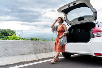 Happy and relaxation time in holiday, Young woman traveler sitting on back car and looking at beautiful mountain view with nature, Traveler car concept