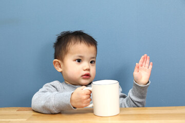コップを持っている男の子。コーヒーブレイク中。