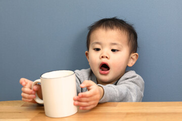 コップを持っている男の子。コーヒーブレイク中。