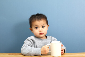 コップを持っている男の子。コーヒーブレイク中。