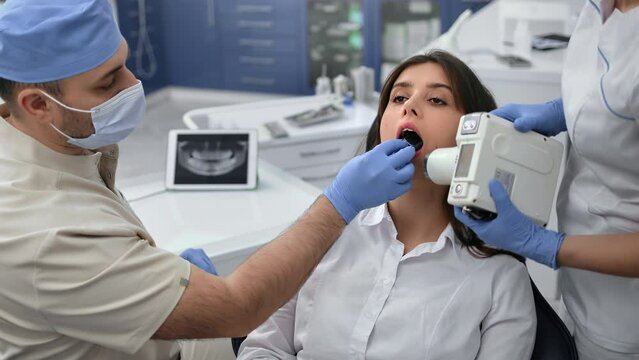 Dentistry doctor and assistant shooting roentgen x ray female patient use equipment medical clinic