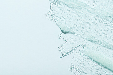 Fototapeta premium Smudge of organic transparent gel cleanser cosmetic product and space for text on turquoise background close upper view