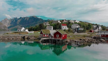 Small village houses scattered on sea beach against hill