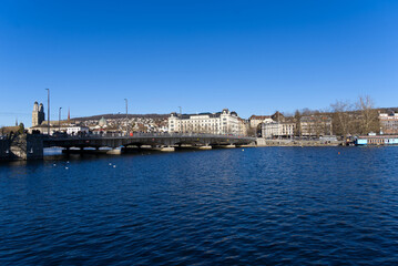 Naklejka premium Cityscape of the old town of Zürich with lake Zürich in the foreground on a sunny winter day. Photo taken February 5th, 2022, Zurich, Switzerland.