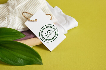 green leaves, stacked lingerie and white tag with markings in the form of a seal with the inscription CO2 neutral