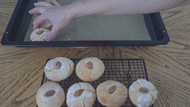 Baked cookies appear on the cooling rack from cookie sheet. The process of making gluten-free almond flour cookies. Step by step. Homemade baking cookies. Biscotti di mandorla siciliani.