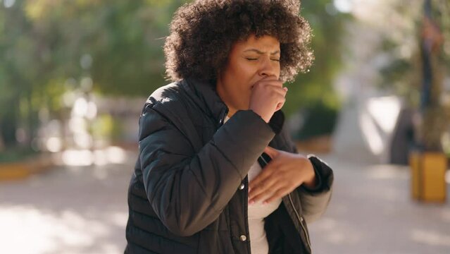 Young african american woman coughing at park