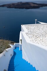 A door and steps leading to a residential building with a beautiful view on the Aegean Sea and the volcano of Santorini in Greece