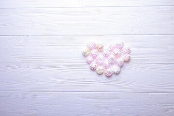 Heart of candy on a wooden background with place for text. Meringue heart