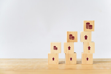 different size of  coin and rising arrow icon on wood block for increasing revenue, income, profit or stock market concept