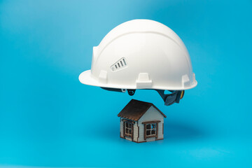 Fototapeta na wymiar House insurance concept. Insured house under protection of helmet. Copy space.